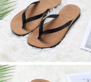Close-up of casual women's flip-flops with brown soles and black straps on a soft rug