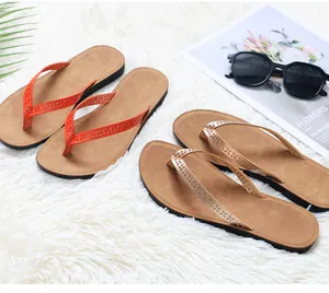Detailed view of two pairs of stylish women's PU leather flip-flops on a white plush rug.