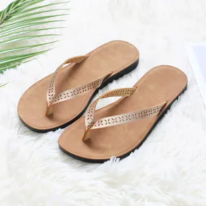 Stylish women's brown PU leather flip-flops featuring laser-cut floral pattern straps