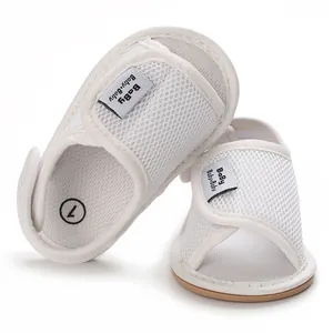 Close-up of white mesh baby walking shoes with soft rubber soles and Velcro straps.