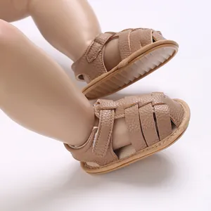 Close-up macro view of brown faux leather baby sandals with anti-slip soles for infants