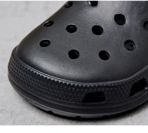 Vue rapprochée détaillée des sabots de plage noirs pour hommes avec texture perforée