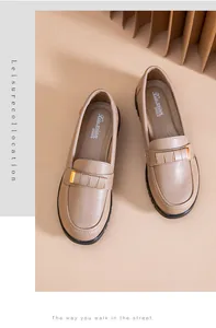Top-down view of soft beige loafers with gold metal bar detailing and padded insoles.