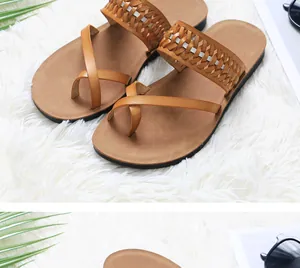 Detailed macro view of stylish brown woven strap flat thong sandals on soft white rug