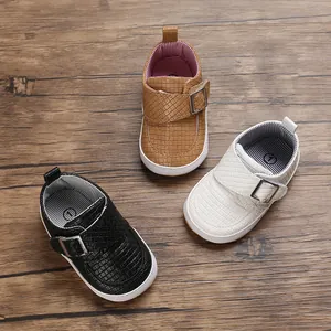 Detailansicht von gewebten Baby-Lauflernschuhen mit weicher Sohle in Schwarz, Braun und Weiß.