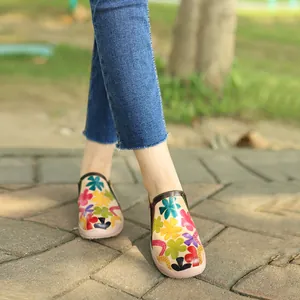 Vista detallada de zapatos planos retro con estampado floral hechos a mano fuera
