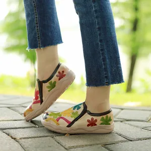 Vista detallada de mocasines de cuero con estampado floral vintage usados al aire libre