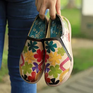 Detalle de zapatos planos retro para mujer hechos a mano con vibrantes flores.