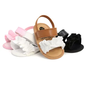 Detailansicht von Baby-Sandalen mit Rüschen in Rosa, Weiß, Hellbraun und Schwarz.