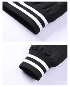Macro detail shot of a black baseball jacket showing white striped ribbed cuffs