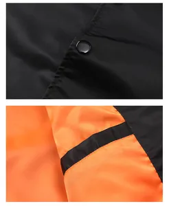 Detail of black bomber jacket featuring snap button and contrast orange lining