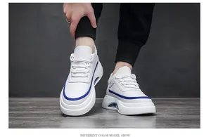Detalle de zapatillas blancas para hombre con ribete azul y suela con cámara de aire.