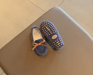 Detail view of navy blue toddler loafers with bow and non-slip sole texture