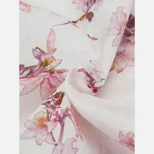 Detailed close-up of lightweight white fabric with soft pink floral print pattern
