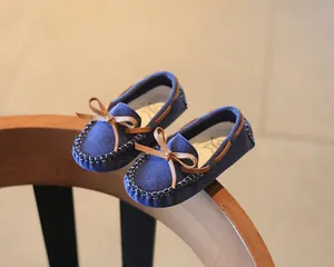 Detailed view of blue suede children's loafers featuring a stylish brown bow detail