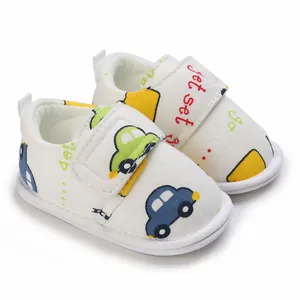 Vue détaillée de chaussures de marche bébé blanches avec motifs voitures.