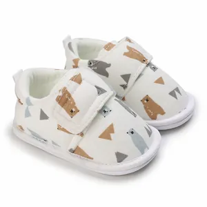 Gros plan détaillé de chaussures de bébé blanches à semelles souples avec oursons