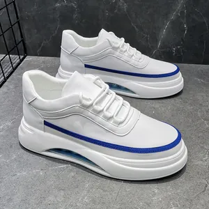 Primer plano de zapatillas blancas para hombre con raya azul y suela de cámara de aire.