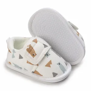 Vue détaillée de chaussures pour bébé avec motif ours et semelle souple antidérapante.
