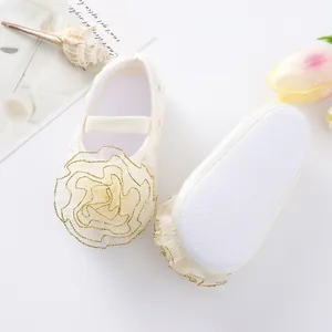 Detailed view of baby girl princess shoes with large floral accent and non-slip sole.