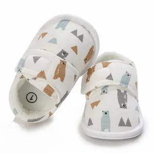Détail de chaussures de marche pour bébé avec motifs d'ours et fermeture à scratch pratique
