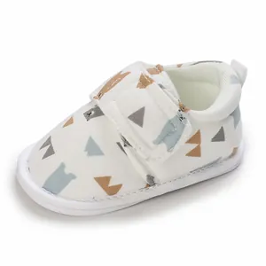 Vue détaillée d'une chaussure de marche bébé souple blanche avec motif ours mignon et sangle