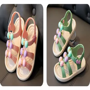 Detailed view of girls' summer sandals with pastel bows in pink and green colors