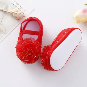 Detailed view of red baby girl princess shoes featuring large flower and non-slip soles