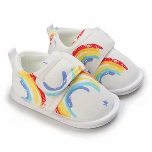 Détail de chaussures de marche souples pour bébé avec imprimé arc-en-ciel et velcro