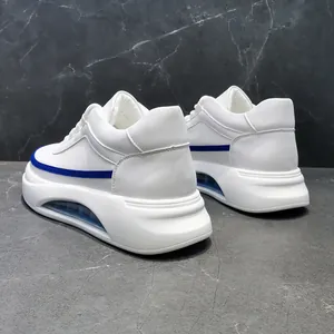 Primer plano de zapatillas blancas para hombre con suela de aire y raya azul.
