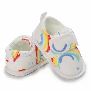 Gros plan de chaussures de marche pour bébé avec imprimés arc-en-ciel et velcro