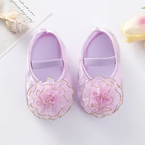 Detailed view of lavender baby princess shoes with large ruffled flowers and soft soles