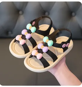 Close-up of girls' summer sandals with colorful 3D bows and flexible beige soles
