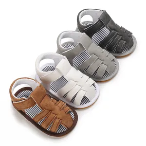 Detalle de sandalias para bebés en marrón, blanco y gris con suelas de goma suave de verano
