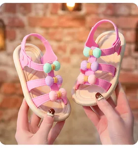 Detailed view of pink girl's sandals with colorful 3D bow decorations and soft sole