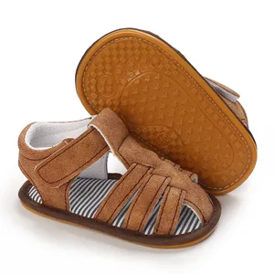 Sandalias de ante marrón para bebé con suela de goma blanda y plantilla de rayas.