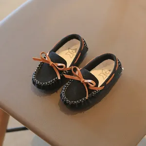Elegant children's black suede loafers featuring a brown bow-knot and stitch details