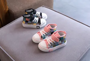 Dettaglio ravvicinato di scarpe in tela a scacchi alte per neonati e bambini.