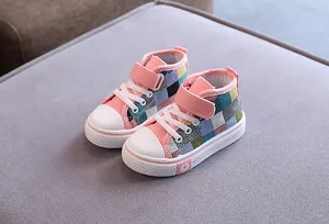 Dettaglio di scarpe di tela alte per bambini con motivo a quadri colorati e velcro