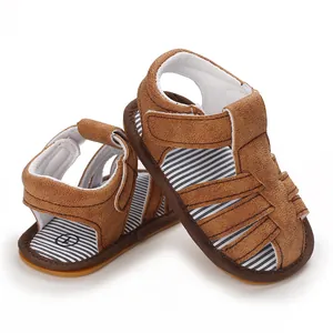 Primer plano de sandalias para bebé en ante marrón con suelas de goma muy suaves.