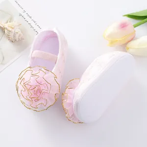 Close-up of pink baby princess shoes with large ruffled flower and anti-slip sole