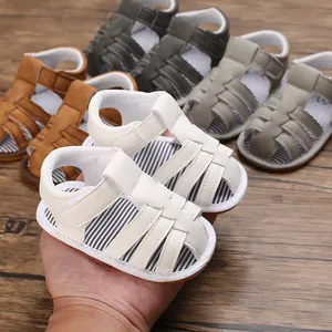 Sandales souples pour bébé de 0 à 12 mois en plusieurs couleurs sur fond en bois