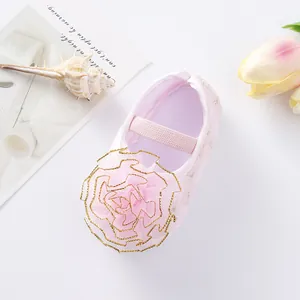 Detail of pink baby princess shoe featuring an elegant mesh flower and soft sole