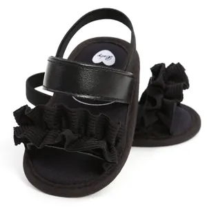 Detailansicht der schwarzen Baby-Sandalen mit Rüschen und weicher Sohle für kleine Mädchen