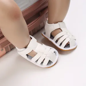 Détail de sandales blanches pour bébé à semelle souple avec semelles rayées et velcro