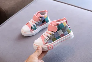 Dettaglio di scarpe alte in tela a scacchi per bambini con suole antiscivolo e fiore margherita