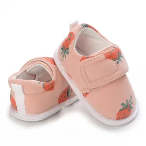 Vue détaillée de chaussures roses pour bébé avec motif fraise et fermeture velcro pratique