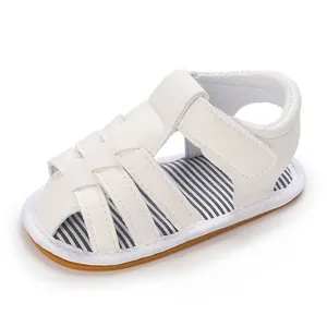 Detalle de sandalias blancas para bebé niño con suela de goma blanda y tiras transpirables