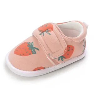 Détail d'une chaussure de marche bébé imprimé fraise avec sangle velcro souple