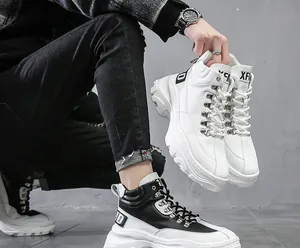 Dettaglio di sneaker alte da uomo con suola platform e occhielli in metallo color block.